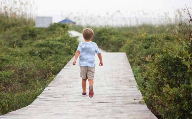 A little boy running on a deck